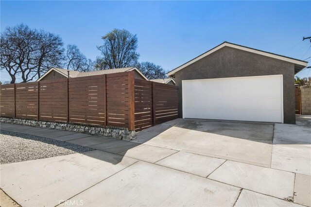 garage with driveway and fence