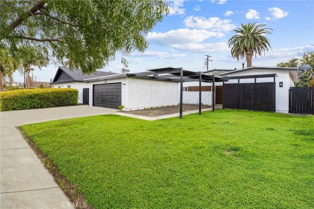 view of yard with fence, a garage, and driveway