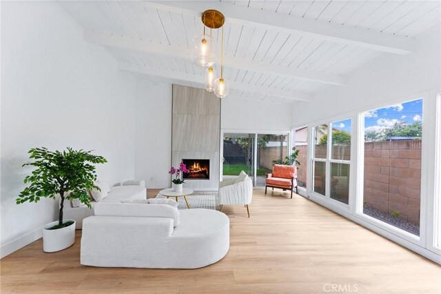 interior space with wooden ceiling, a fireplace, and vaulted ceiling with beams