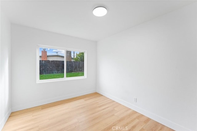 unfurnished room with baseboards and light wood-style floors