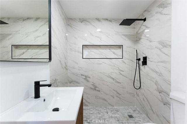 bathroom featuring a marble finish shower, toilet, and vanity