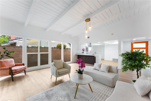 living area featuring visible vents, light wood finished floors, high vaulted ceiling, wood ceiling, and beamed ceiling