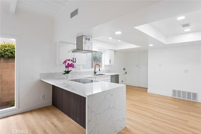 kitchen featuring visible vents, white cabinetry, a sink, dishwasher, and island range hood