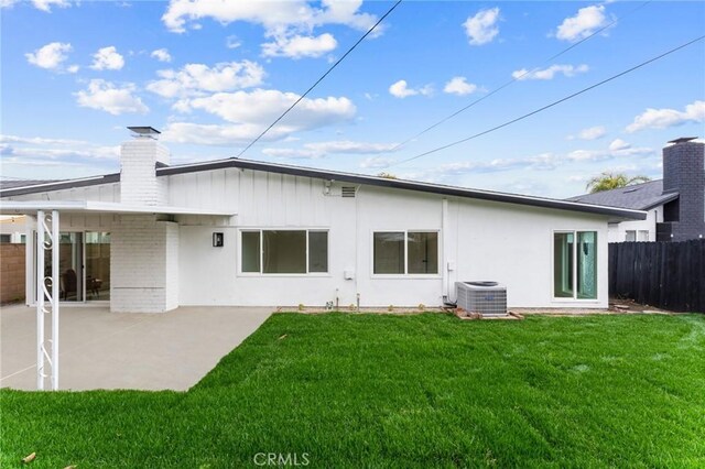 back of house with a patio, central AC, fence, a yard, and a chimney