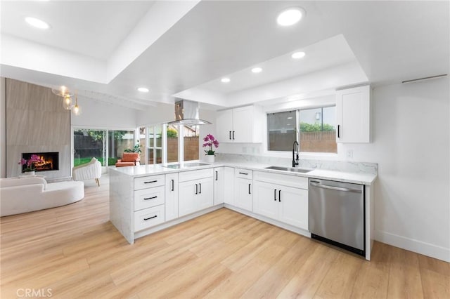 kitchen featuring a peninsula, a sink, stainless steel dishwasher, black electric stovetop, and open floor plan