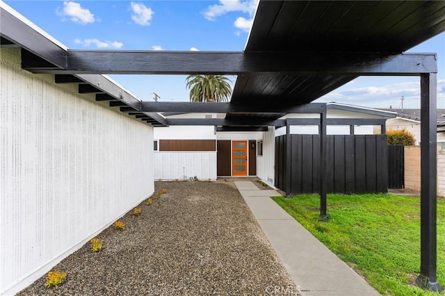 entrance to property with a yard and fence