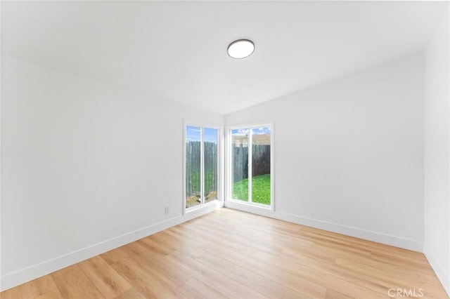 unfurnished room with baseboards and light wood-style flooring