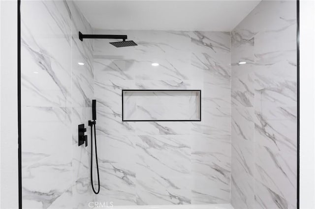 bathroom featuring a marble finish shower