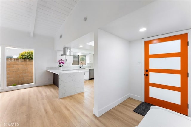 foyer entrance with lofted ceiling with beams, light wood-style flooring, and baseboards