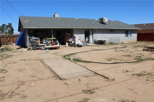 back of house with cooling unit, stucco siding, and fence