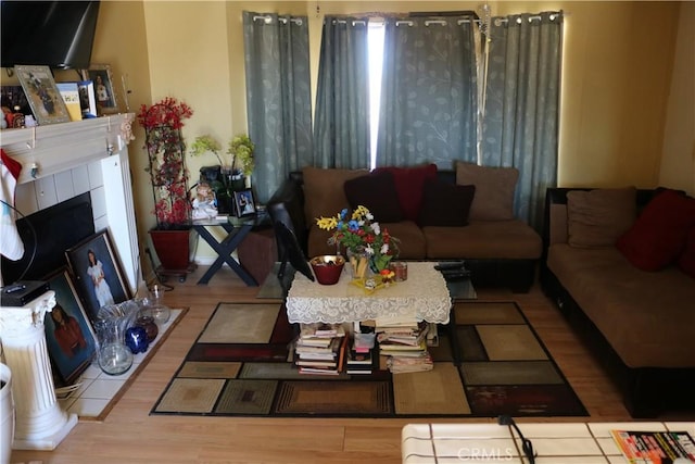 living room featuring wood finished floors and a tile fireplace