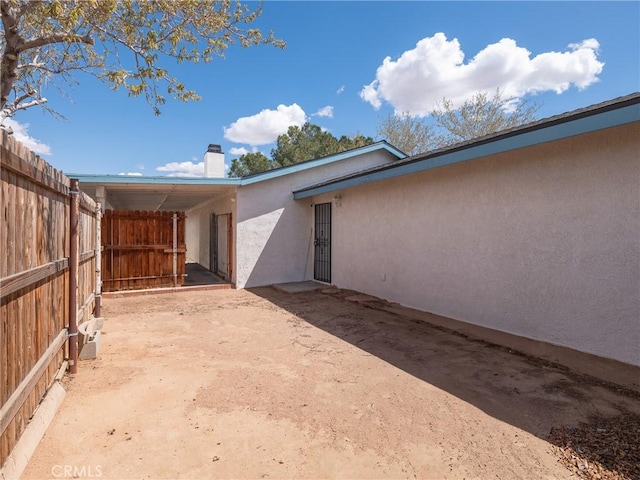 14606 Orange St, Hesperia, CA 92345 - exterior space featuring fence, stucco siding, and a chimney