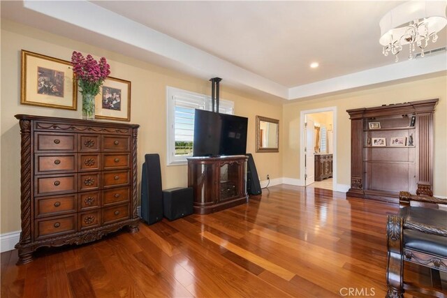 living room with visible vents, baseboards, recessed lighting, an inviting chandelier, and wood finished floors