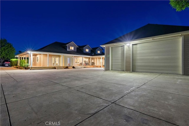 view of front of property with a garage, an outbuilding, and a porch