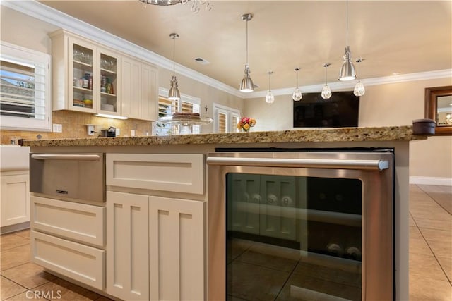 bar featuring wine cooler, ornamental molding, and hanging light fixtures