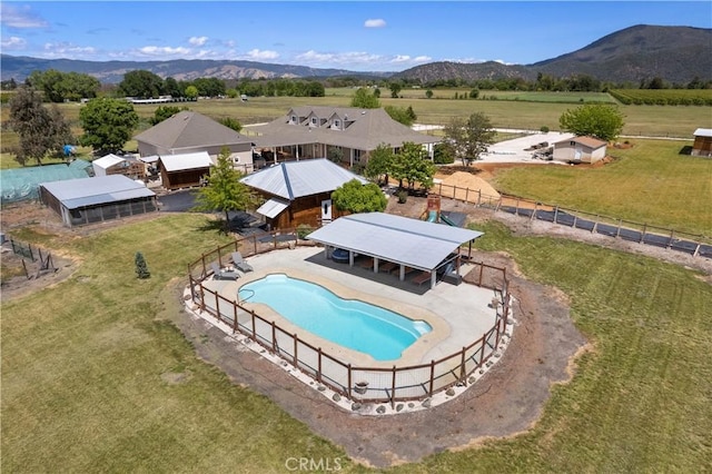 view of pool featuring an outbuilding, a rural view, a mountain view, and fence