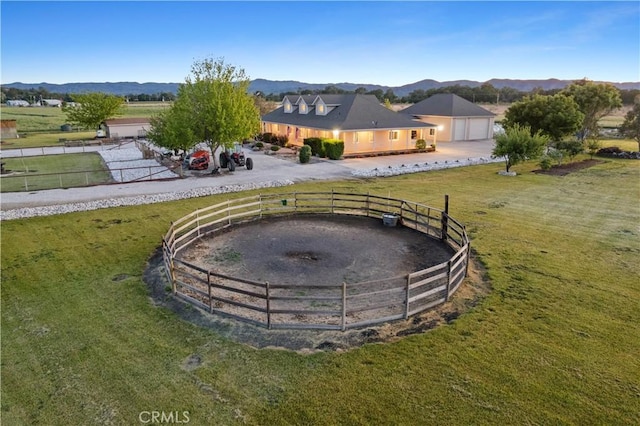 view of yard with fence, a rural view, and a mountain view