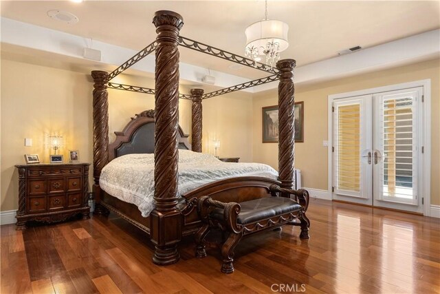 bedroom featuring access to exterior, visible vents, baseboards, and hardwood / wood-style floors