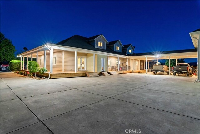 back of house at twilight featuring covered porch