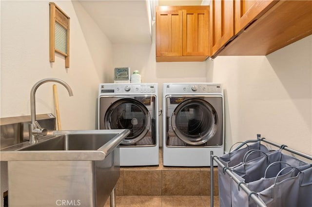 laundry room with washer and clothes dryer, tile patterned flooring, cabinet space, and a sink