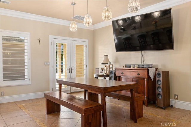 tiled dining room with visible vents, baseboards, crown molding, and french doors