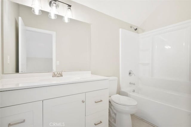 bathroom with vanity, vaulted ceiling, toilet, and washtub / shower combination