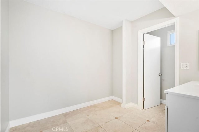 spare room with light tile patterned floors and baseboards