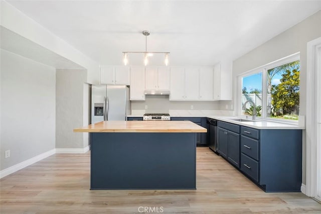 kitchen with stainless steel fridge with ice dispenser, a sink, under cabinet range hood, wood counters, and range