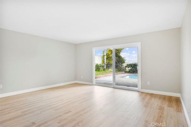 empty room with light wood-style floors and baseboards