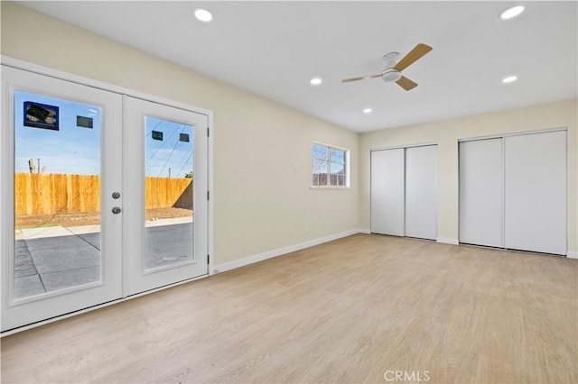 unfurnished bedroom with recessed lighting, french doors, access to outside, light wood-type flooring, and two closets