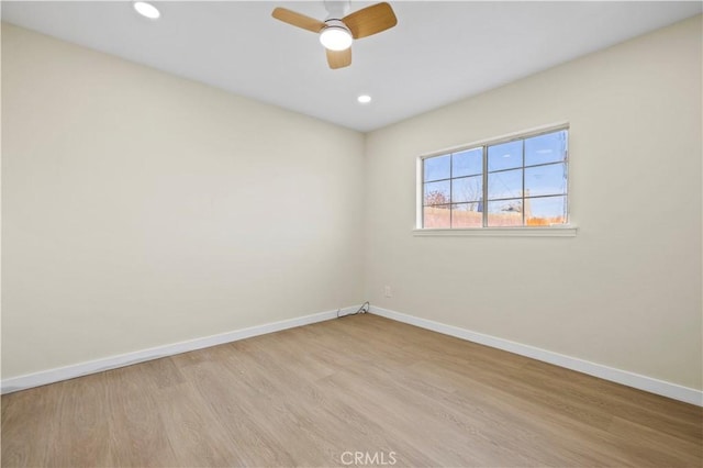 spare room featuring light wood finished floors, recessed lighting, ceiling fan, and baseboards