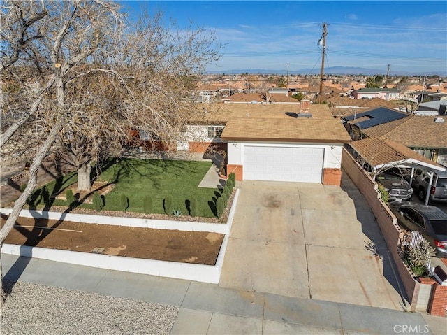 ranch-style house featuring concrete driveway, a garage, and a front lawn