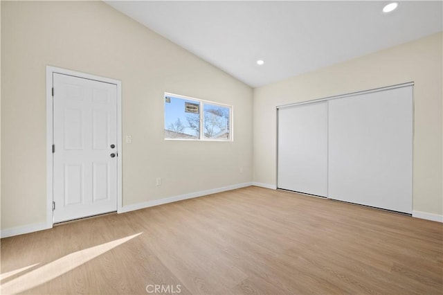 unfurnished bedroom featuring vaulted ceiling, recessed lighting, wood finished floors, and baseboards