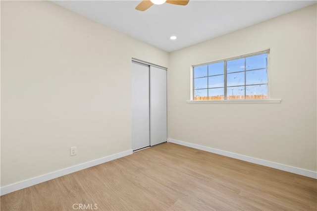 unfurnished bedroom featuring recessed lighting, a closet, light wood-style floors, baseboards, and ceiling fan