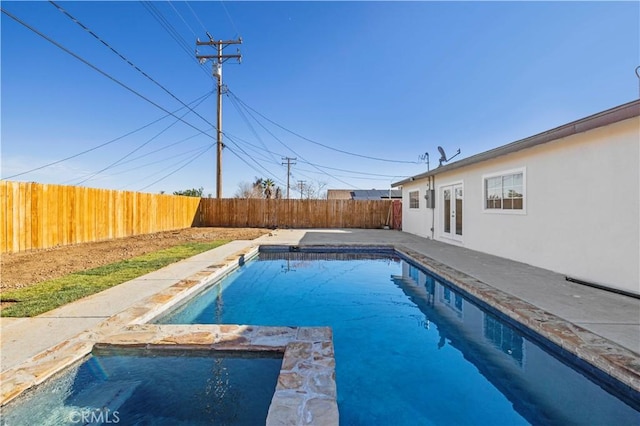 view of pool featuring french doors, a patio, a fenced backyard, and a pool with connected hot tub