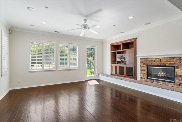 unfurnished living room featuring a fireplace, crown molding, wood finished floors, and baseboards