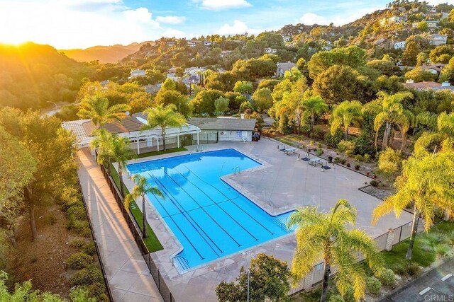 pool featuring a patio area, a mountain view, and fence