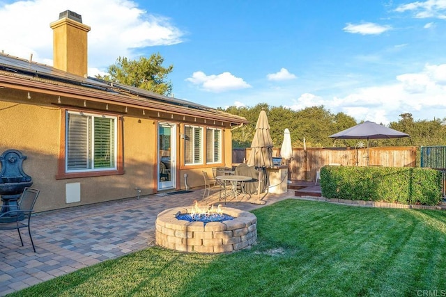 view of yard with a patio, a fire pit, and fence