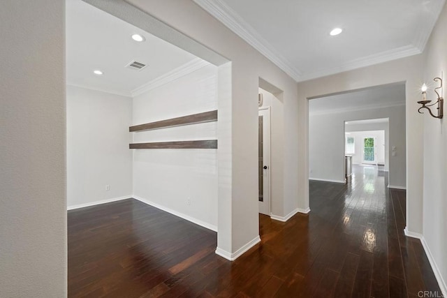 hall with visible vents, wood-type flooring, baseboards, and ornamental molding