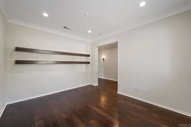 unfurnished room with visible vents, baseboards, wood finished floors, and crown molding