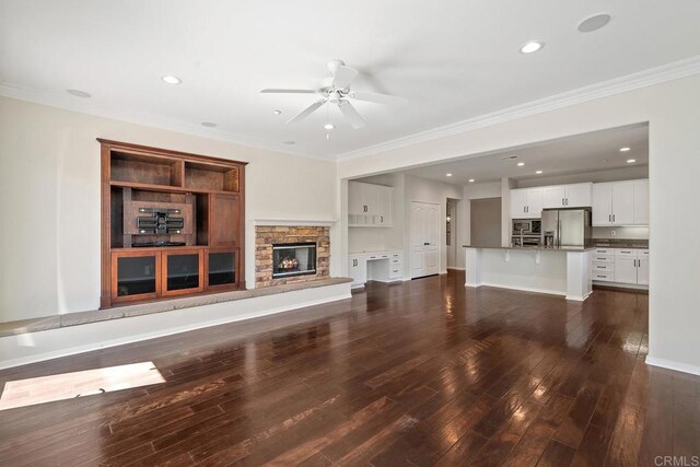 unfurnished living room with dark wood-style floors, a fireplace, recessed lighting, ceiling fan, and ornamental molding