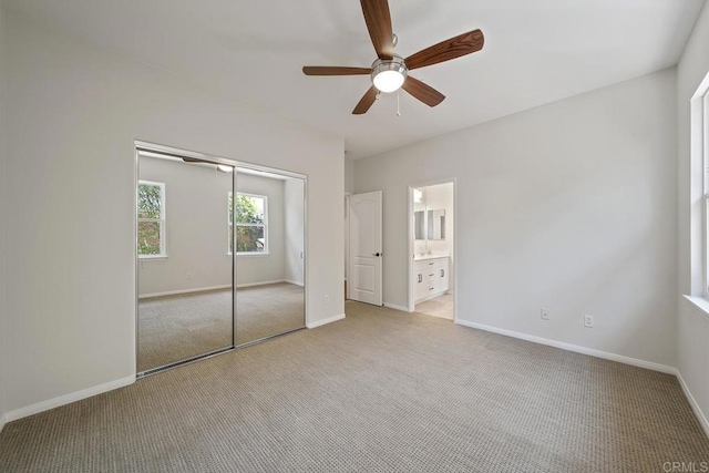 unfurnished bedroom featuring light carpet, a closet, baseboards, and a ceiling fan