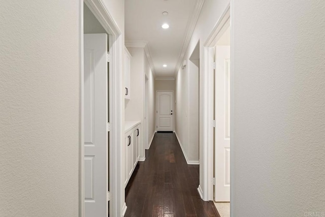 hallway with dark wood finished floors, recessed lighting, crown molding, baseboards, and a textured wall