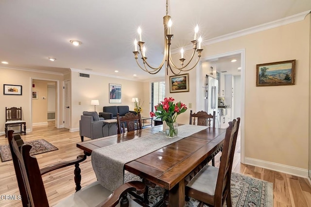 dining space featuring visible vents, baseboards, an inviting chandelier, light wood-style floors, and crown molding