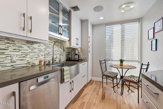 kitchen with dark countertops, visible vents, white cabinets, and stainless steel dishwasher