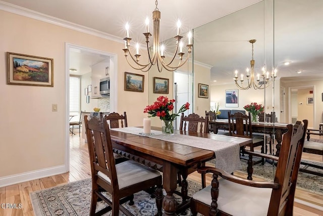 dining room with a notable chandelier, baseboards, crown molding, and light wood-style floors