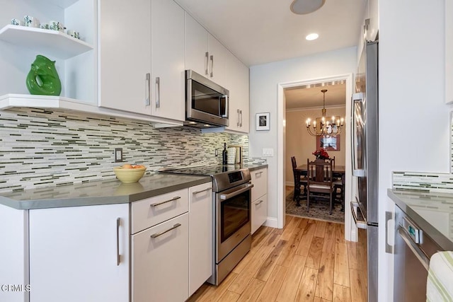 kitchen with decorative backsplash, dark countertops, white cabinetry, and stainless steel appliances