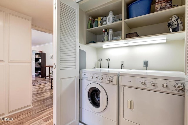 laundry room with washer and dryer, laundry area, light wood finished floors, and ornamental molding