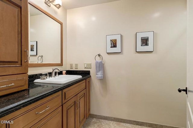 bathroom with vanity, baseboards, and tile patterned flooring