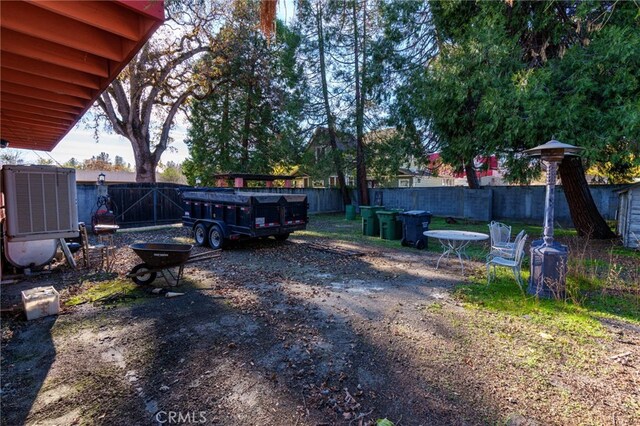 view of yard with central AC and a fenced backyard